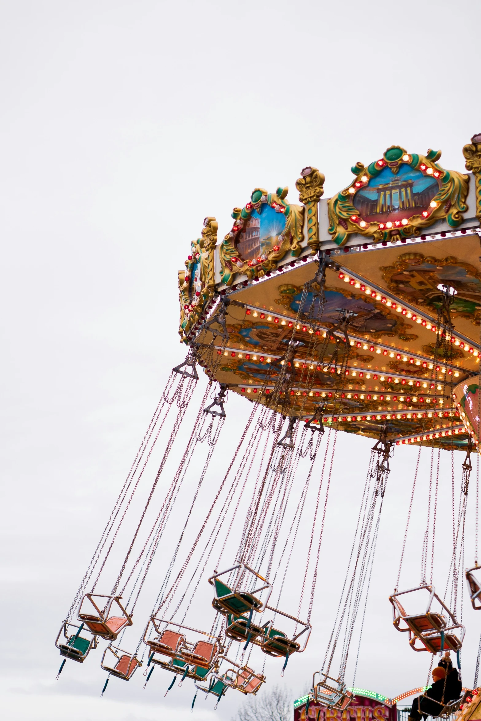 several rides are in the sky with lights hanging above them