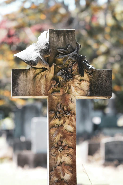 a cross with flowers on it sitting in the grass