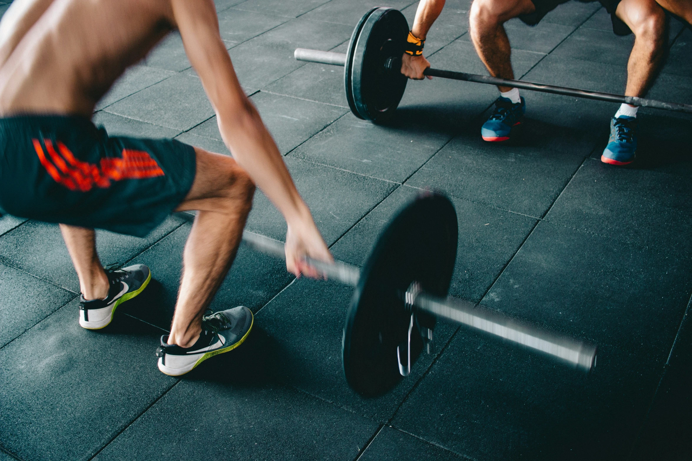 men holding barbells at the gym during a workout