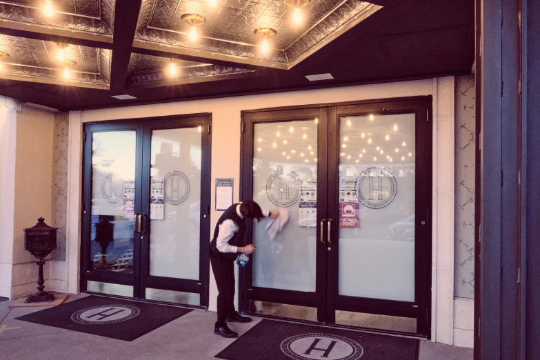 a woman stands at the doorway to her building