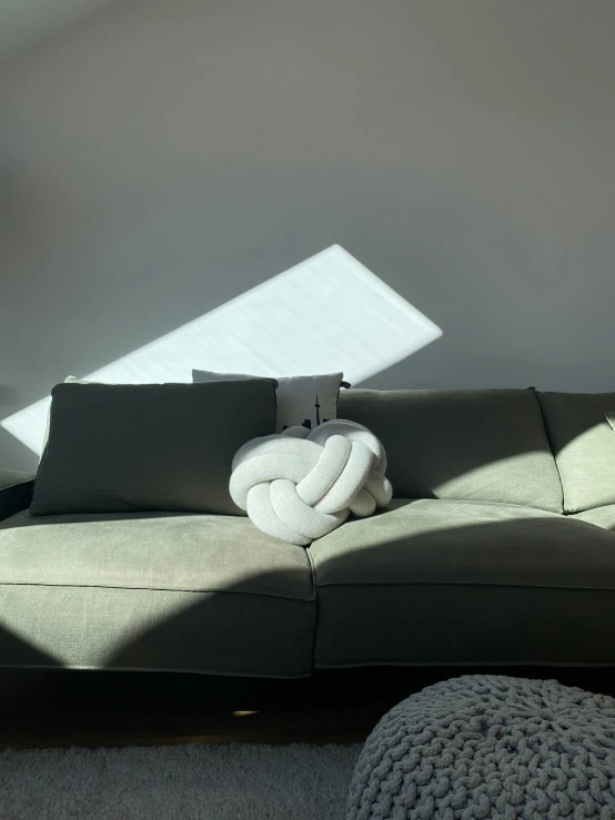 a gray couch covered in pillows and a blanket