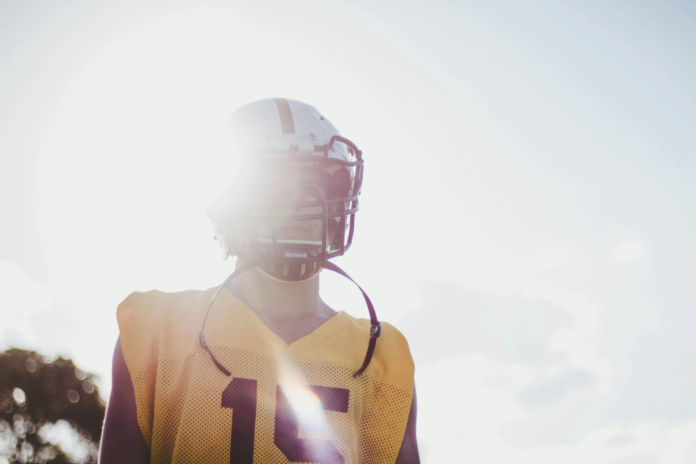 a football player stands on a sunny day