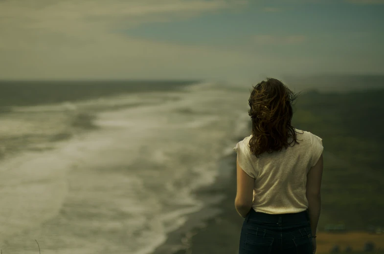 a person standing near the ocean looking at the water