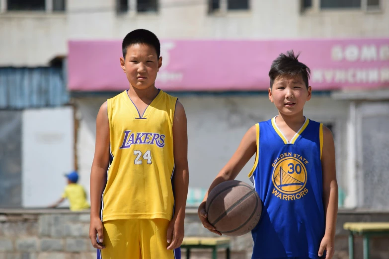 two children are playing a game of basketball