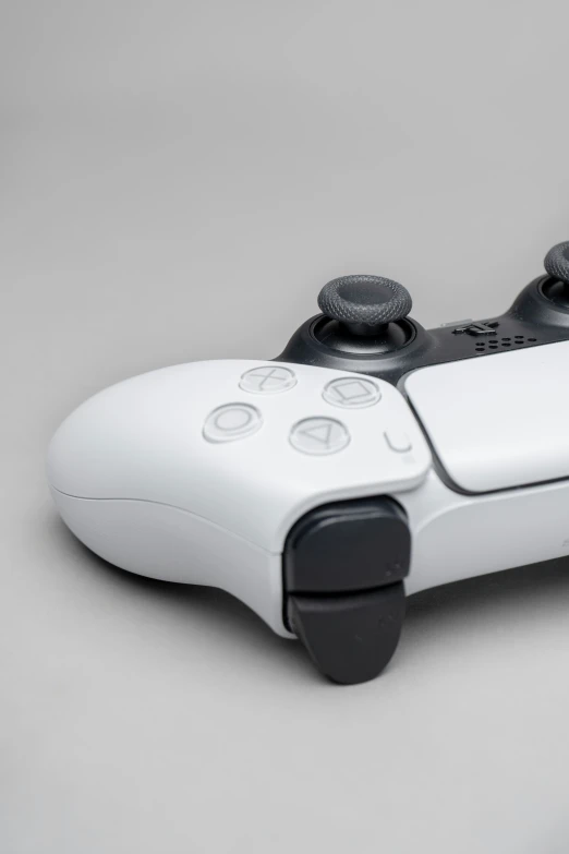 white and black video game controller, on grey surface