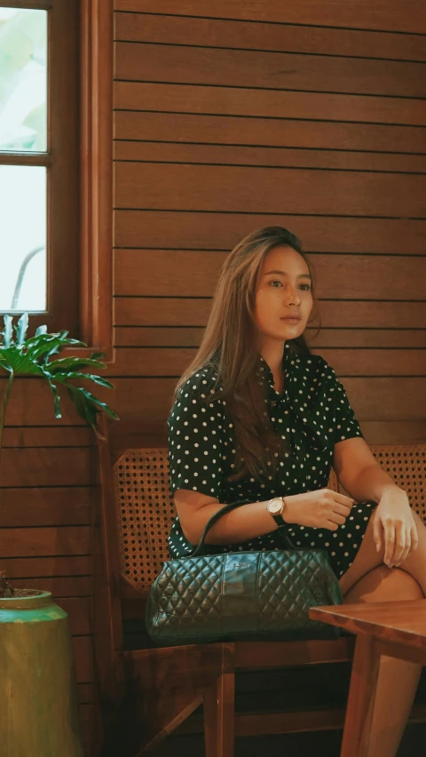 the woman is sitting on a wooden chair