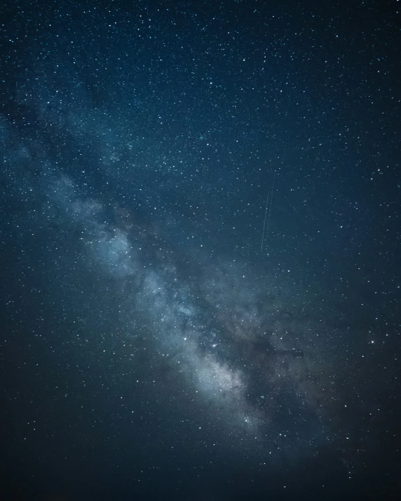 night sky with a line of stars above the ocean