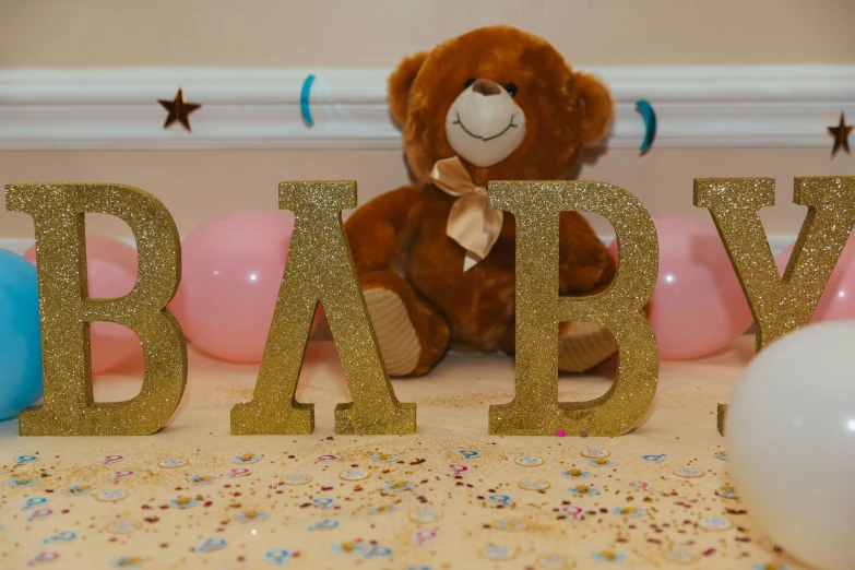 a teddy bear that is next to a baby sign