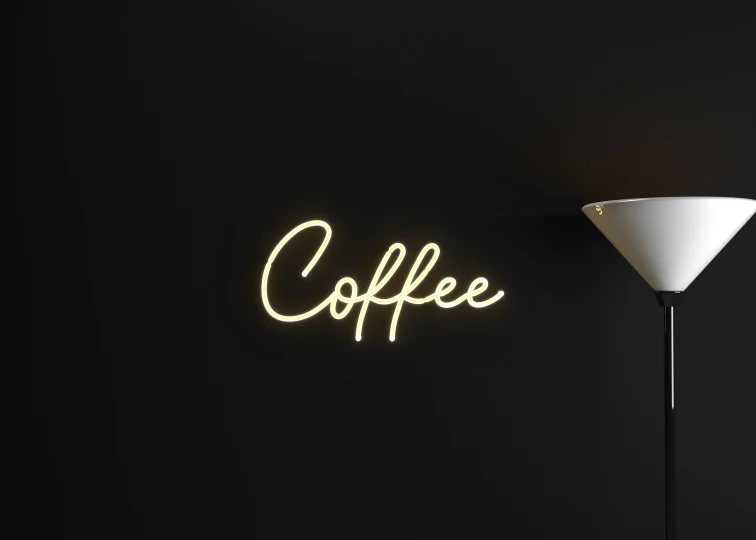 coffee sign hanging on the wall next to a lighted lamp