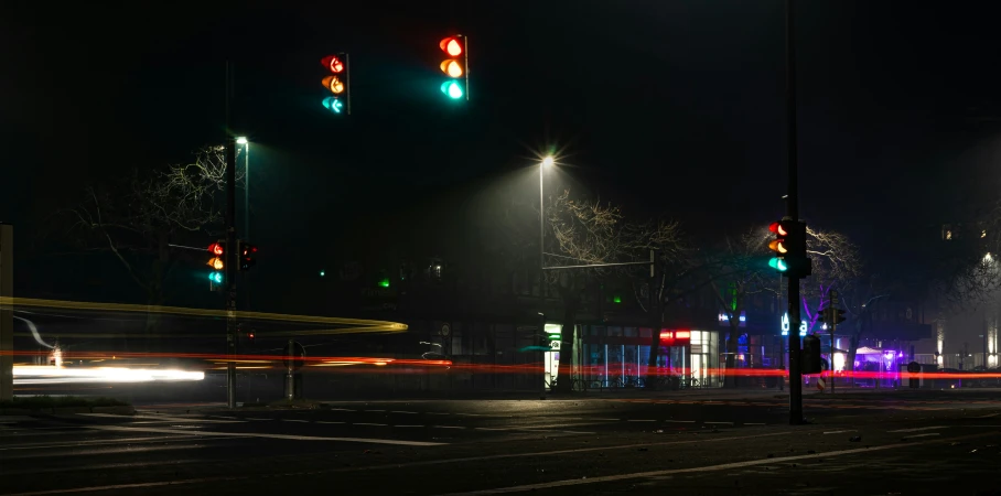 there are four traffic lights at night on the same street