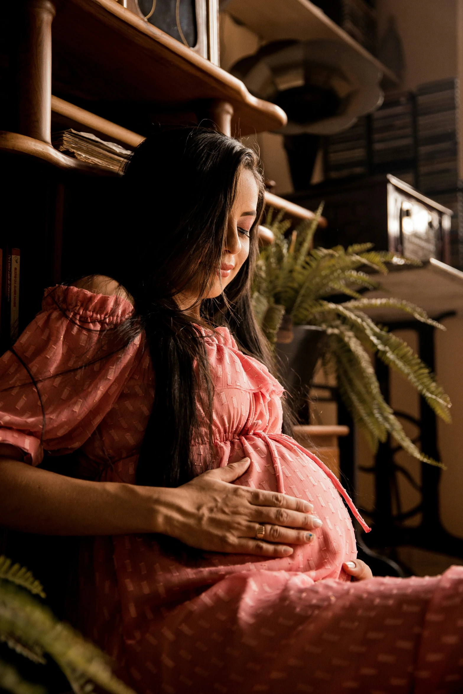 the woman sitting on the floor has her back to her pregnant mother