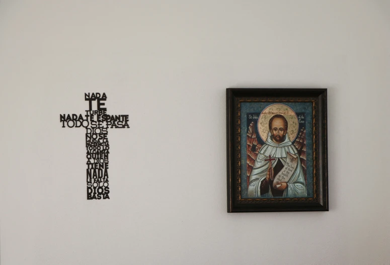 a framed pograph next to a cross hanging on a wall