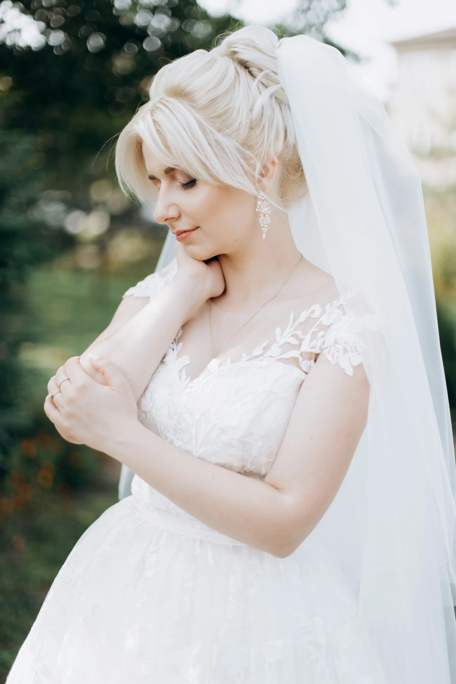 a bride is wearing a white veil and posing