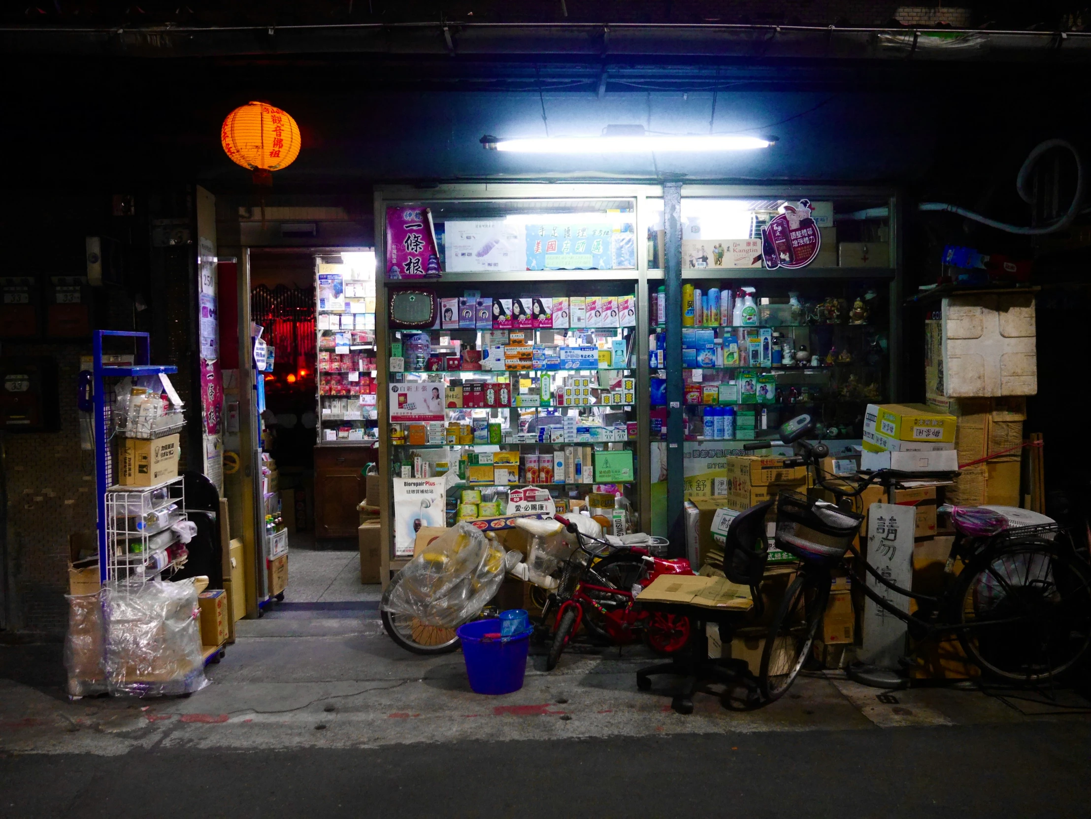 the bicycle shop is very dark and littered with bottles and various goods