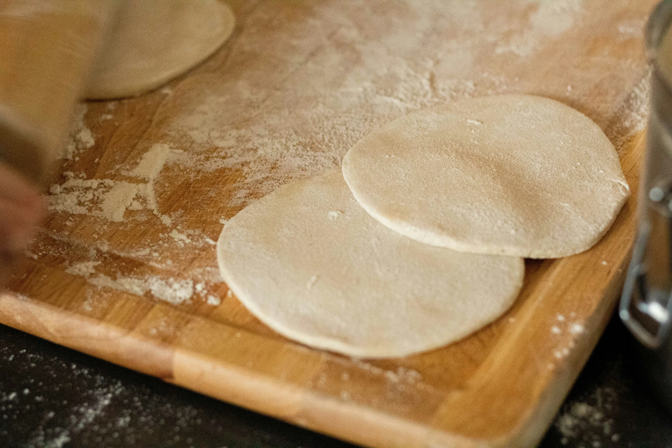 floured pancakes being prepared on a  board