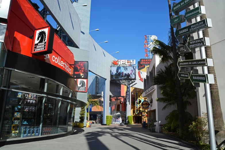 the city street has tall buildings and neon signs on the sides