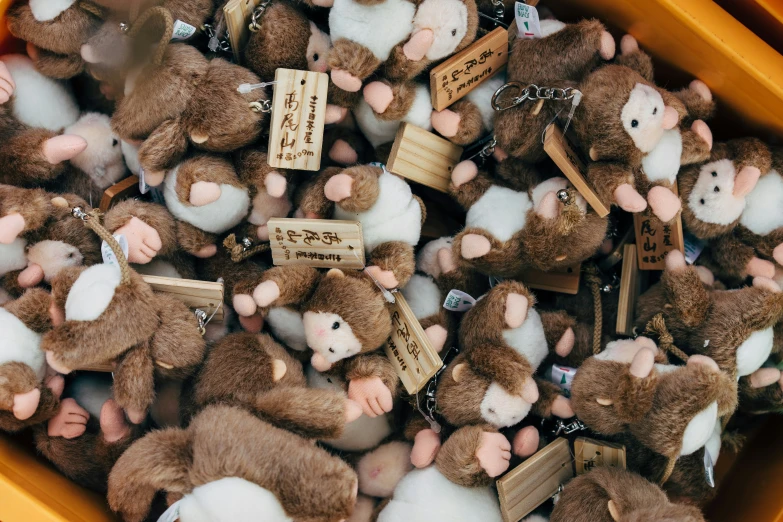 many small brown and white stuffed animals are in a box