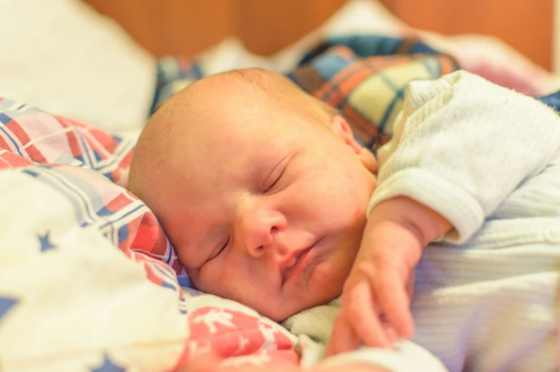 a close up of a baby laying in a bed