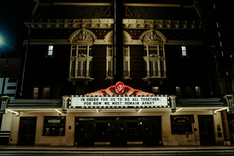 a large theater with a lighted sign in front of it