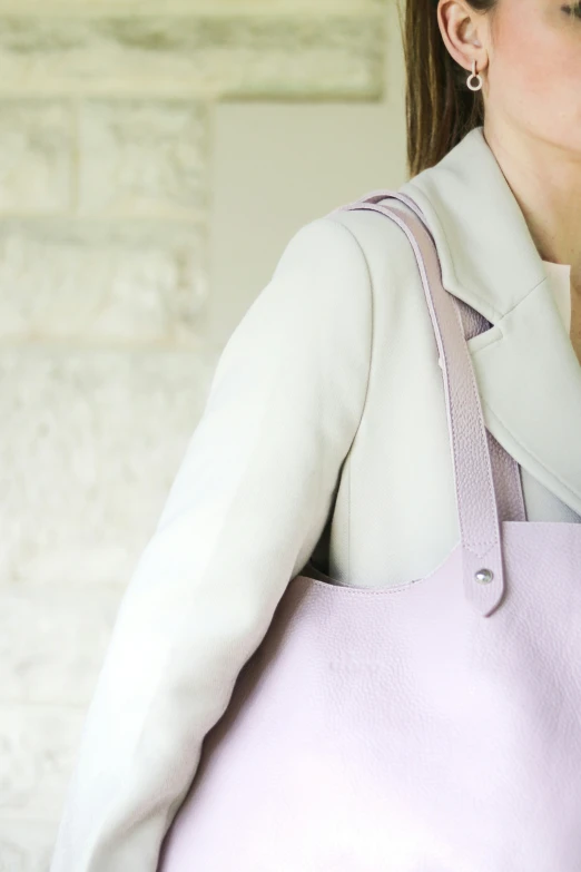 a woman is carrying a pink bag outside