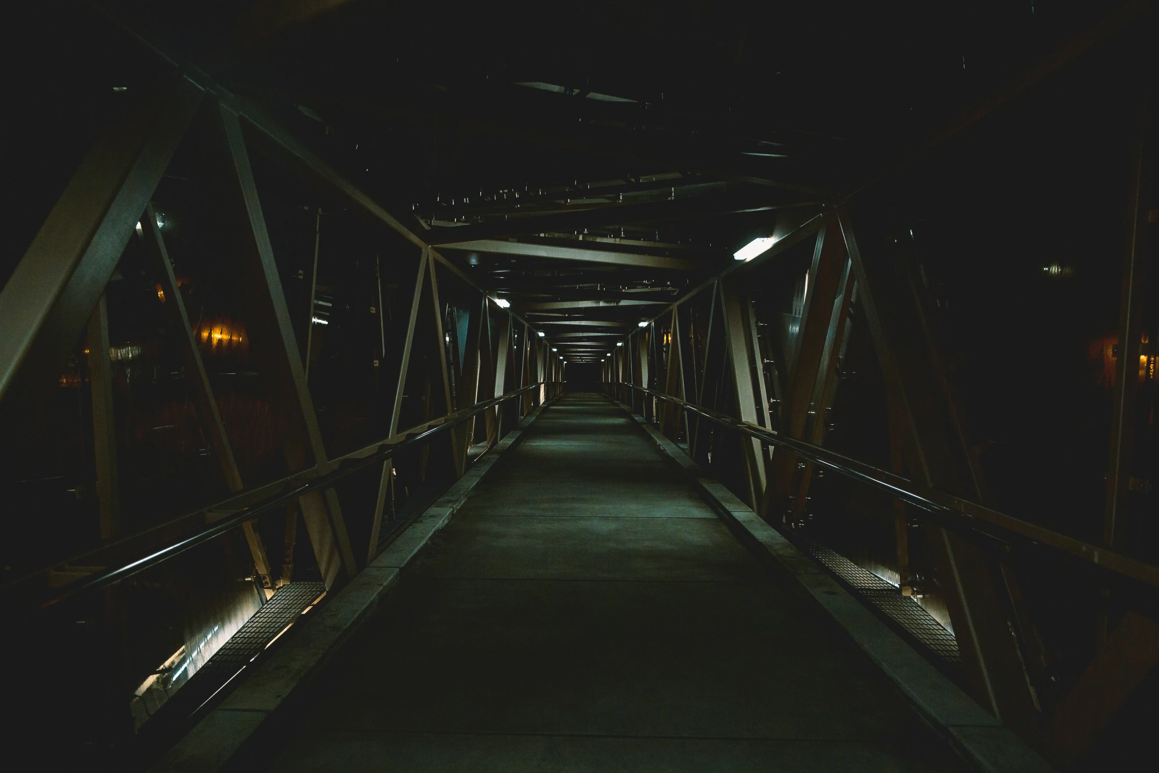 a dark bridge at night is reflecting lights on it