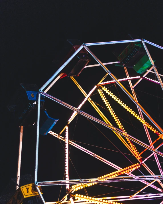 a ferris wheel sitting in front of a dark sky