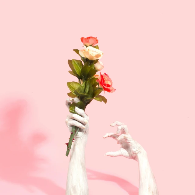 a white glove is holding flowers in one hand