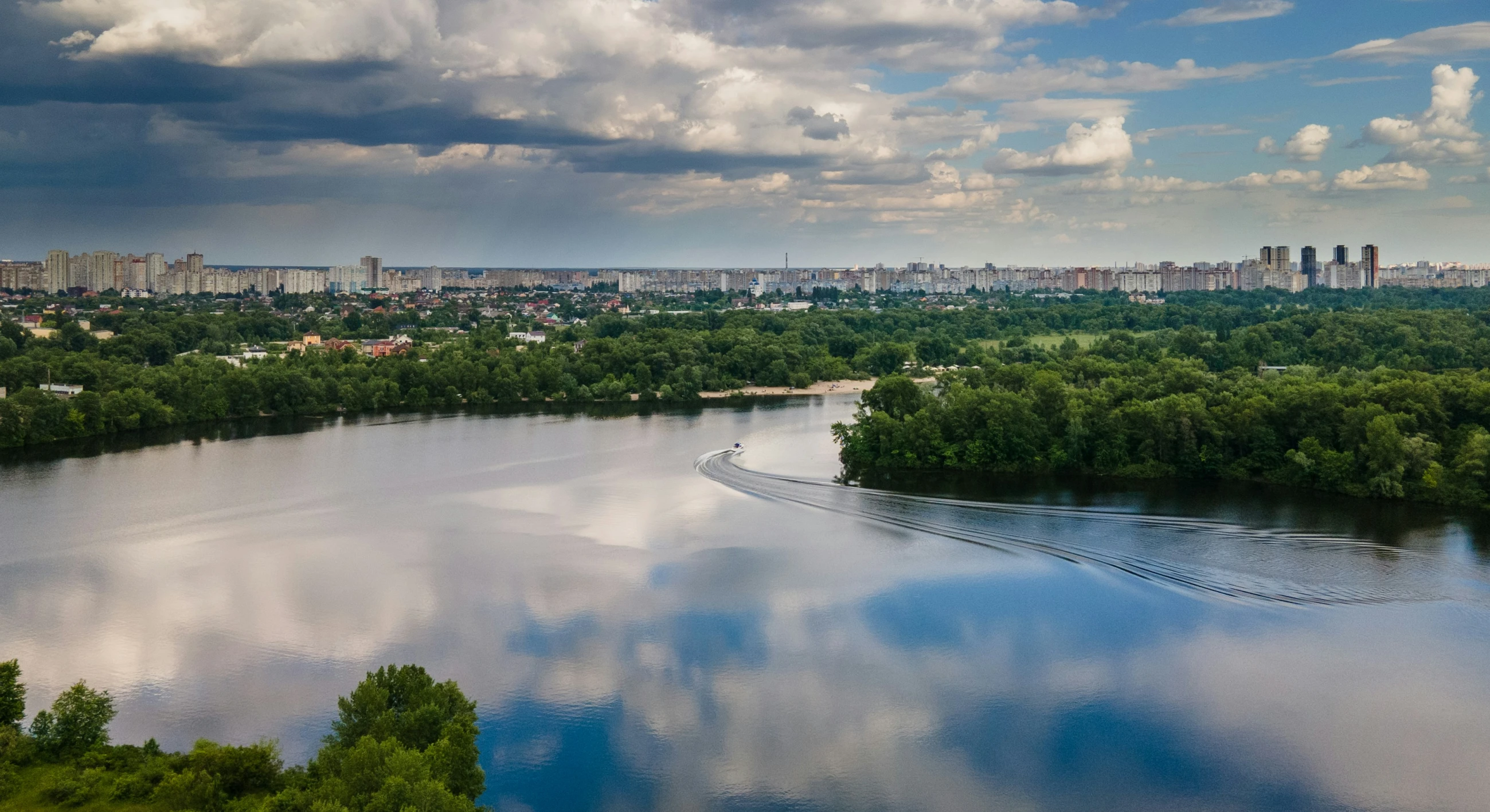 a lake with clouds in the sky is seen