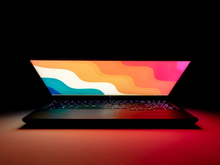 an open laptop computer with multicolored image on screen