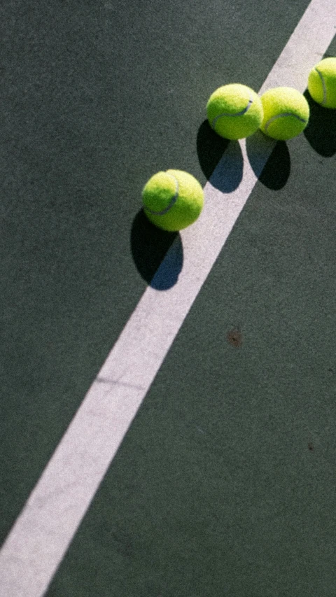 four tennis balls on the tennis court as seen from above