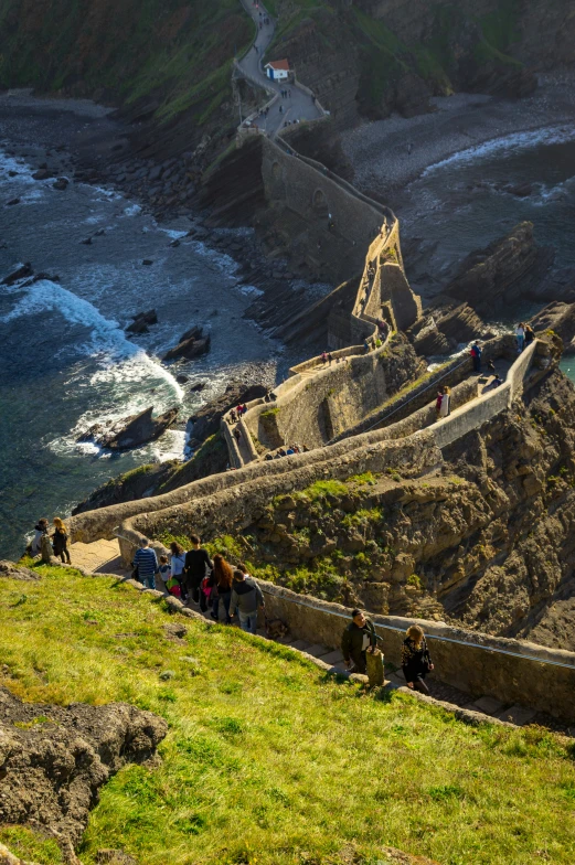 a view from the top of a cliff at a beach with people standing on it