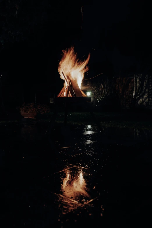 a lit fire in the dark and the water in front