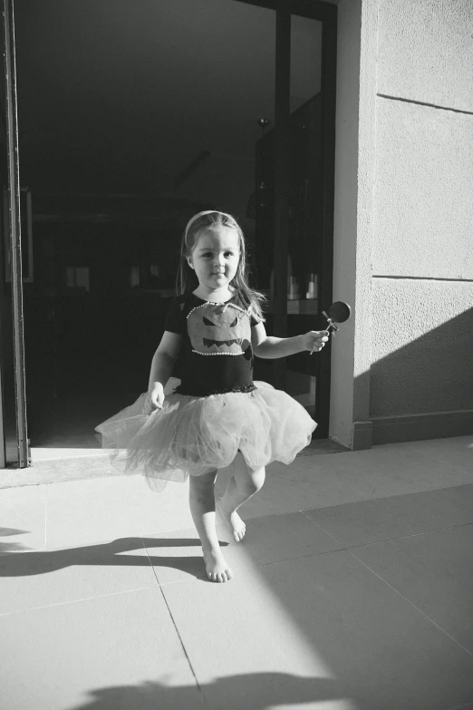 a  in a tutu with her hand on a string