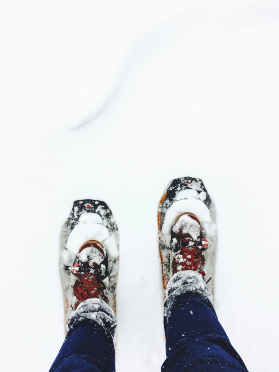 two pairs of shoes are pictured in snow