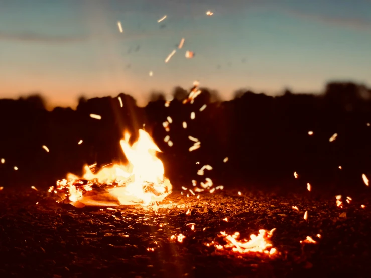 a large bushfire in a field is blazing at night