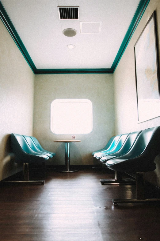 several empty chairs in a train, with one next to the wall