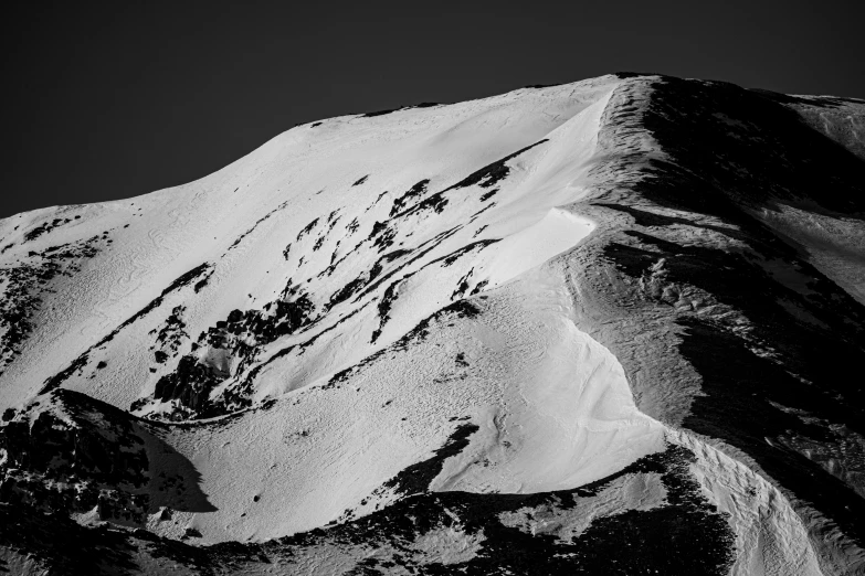 a snow covered mountain against a gray sky