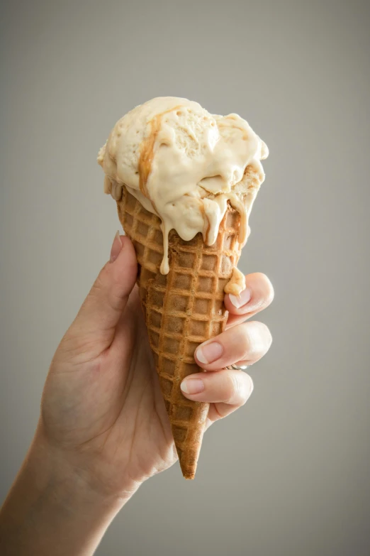 a person holding an ice cream cone with toppings