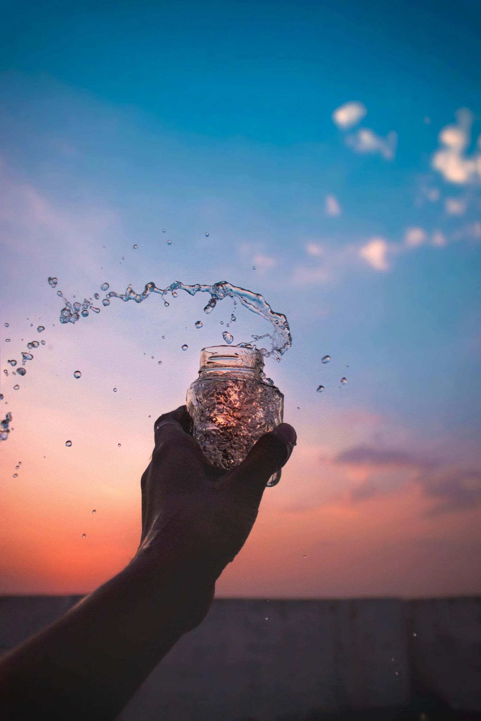 a person is holding a jar with water as it comes out of it