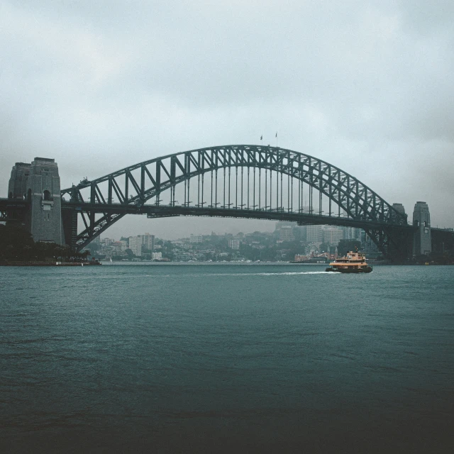 a large boat is in the water under an over pass