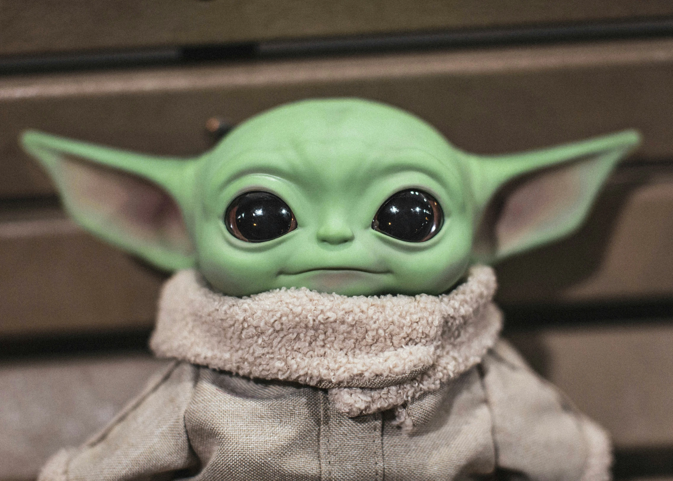 a baby yoda doll in a gray outfit