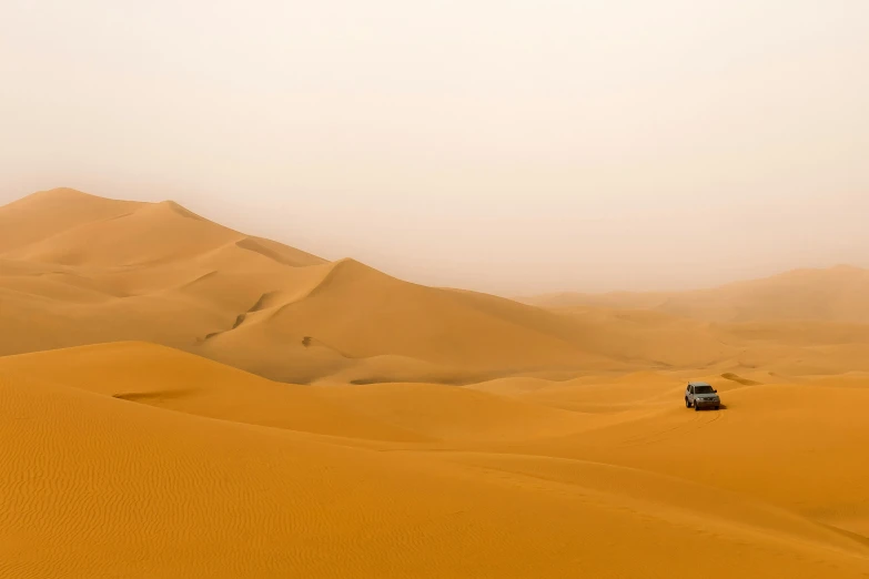 a car driving in the middle of a desert landscape