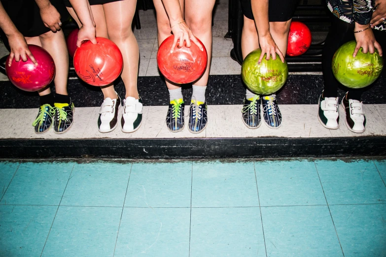 people with skates holding up their bowling balls
