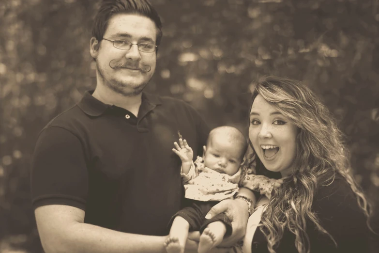 the couple are smiling for the picture while holding their baby