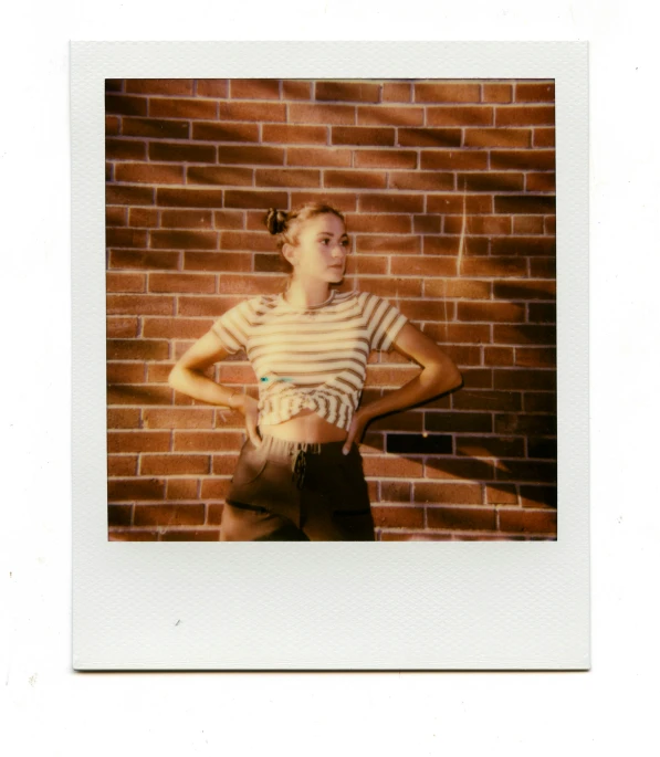 an old po of a young woman in front of a brick wall