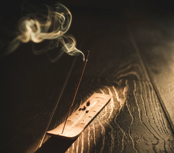 a smoking stick sitting in the dark on top of a table