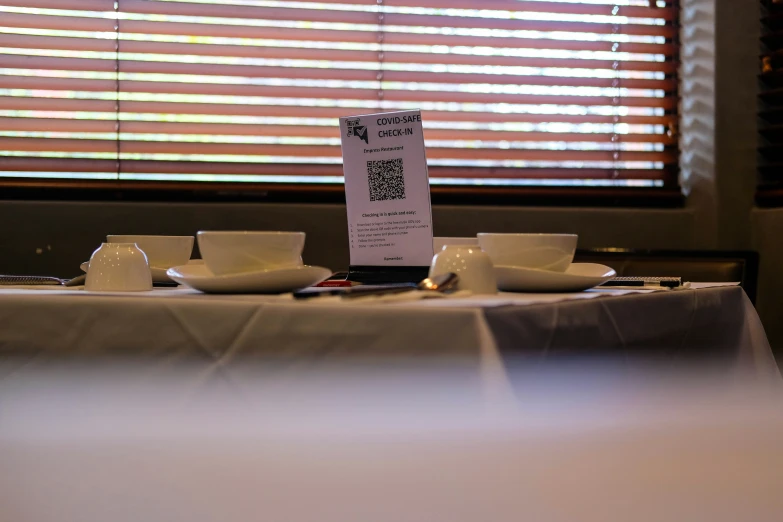 a restaurant with an empty table with two white coffee cups and one empty cup