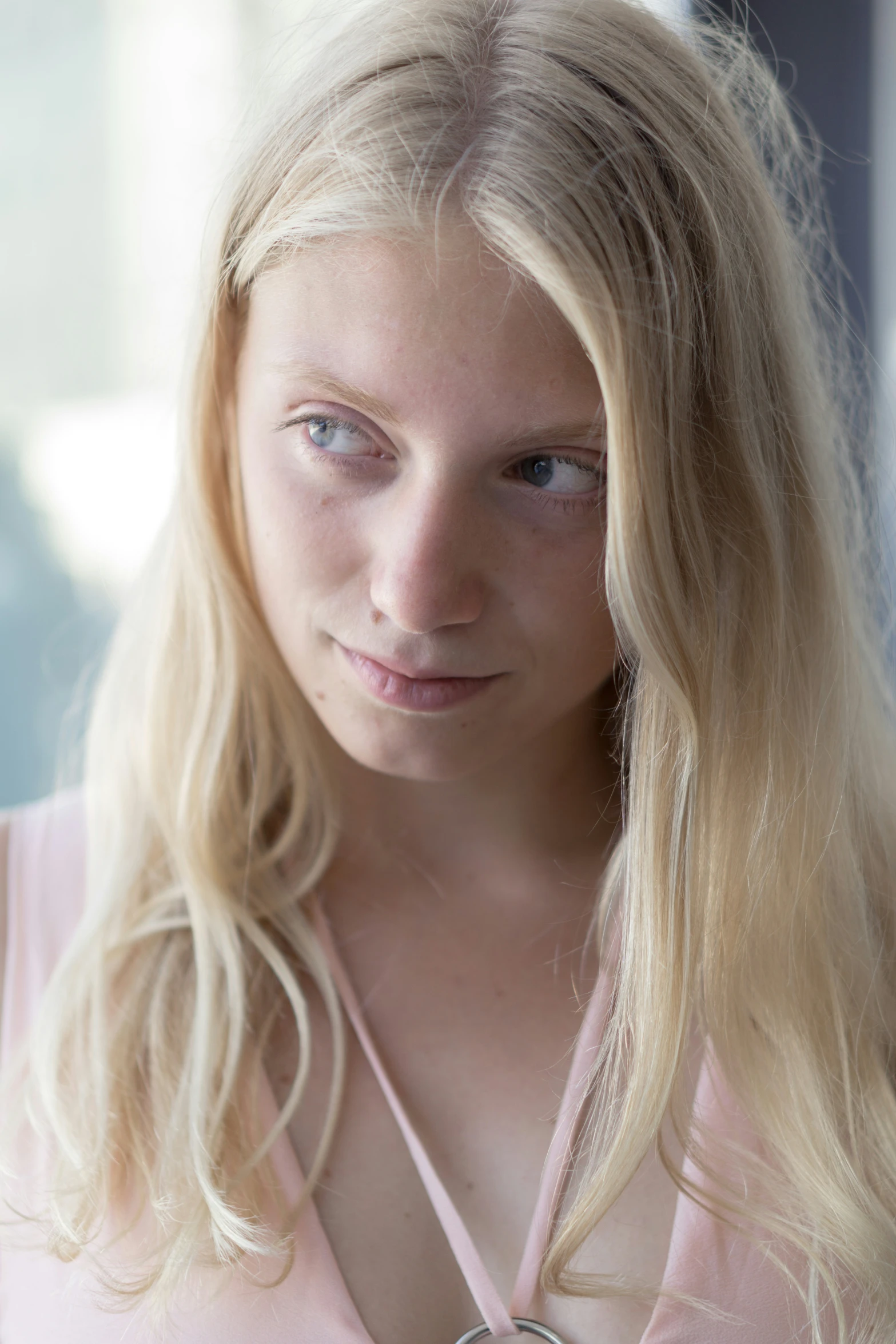 a blonde female is sitting down with her hands behind her back