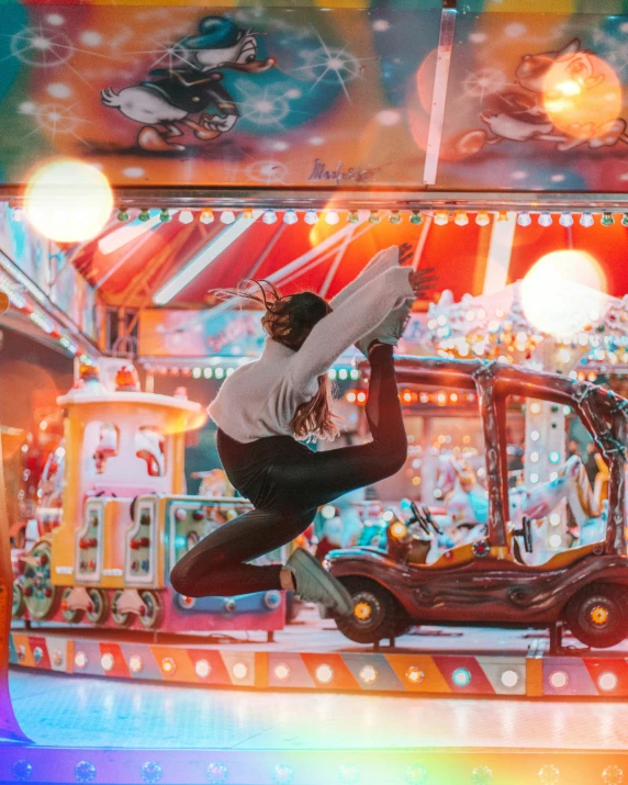 a woman standing on top of a metal carnival wheel