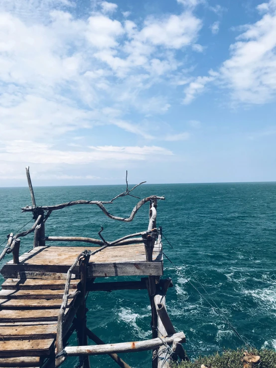 an old wooden bridge with the ocean in the background